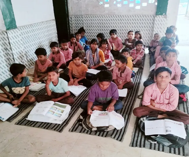 मंडी धनौरा के ग्राम पहाड़पुर इनायत स्थित कंपोजिट विद्यालय में फर्नीचर के अभाव में टाट पर बैठकर पढ़ाई करते विद्यार्थी। जागरण